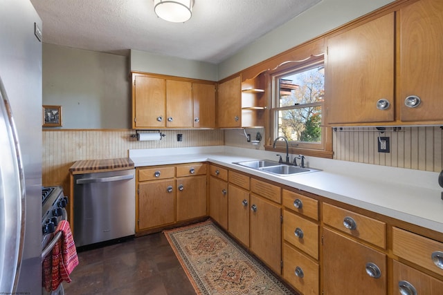 kitchen with appliances with stainless steel finishes, sink, and a textured ceiling