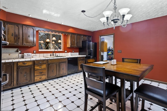 kitchen featuring hanging light fixtures, dark brown cabinets, and black appliances