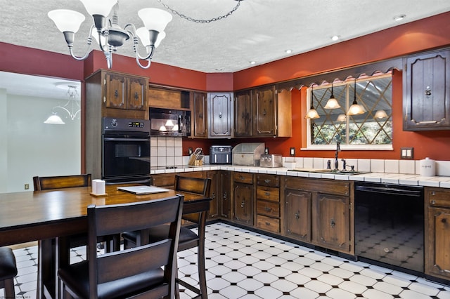 kitchen featuring dark brown cabinets, tile counters, black appliances, and decorative light fixtures