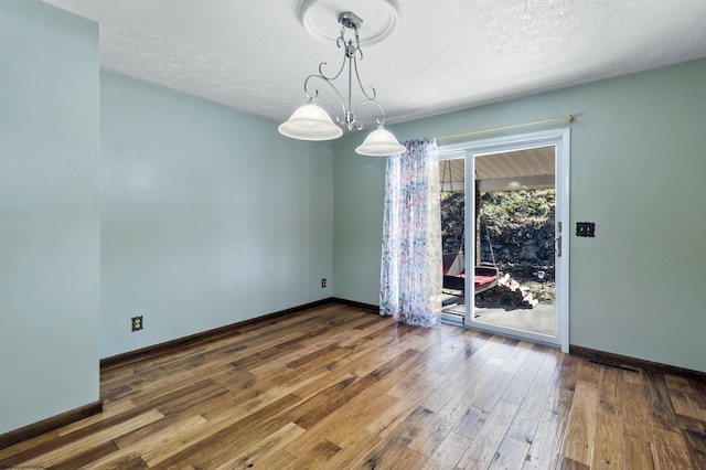 empty room with a textured ceiling and hardwood / wood-style flooring