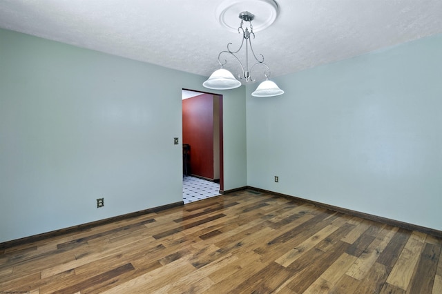 interior space with hardwood / wood-style flooring, a textured ceiling, and a notable chandelier