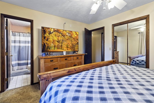 carpeted bedroom with ensuite bathroom, ceiling fan, and a textured ceiling