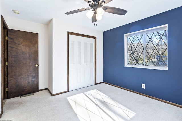 unfurnished bedroom with ceiling fan, a closet, and light colored carpet