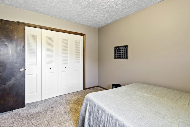 bedroom with a closet, a textured ceiling, and carpet flooring