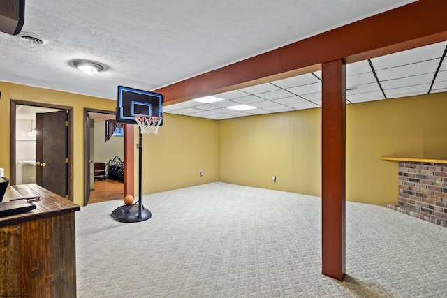 basement featuring a paneled ceiling and carpet floors