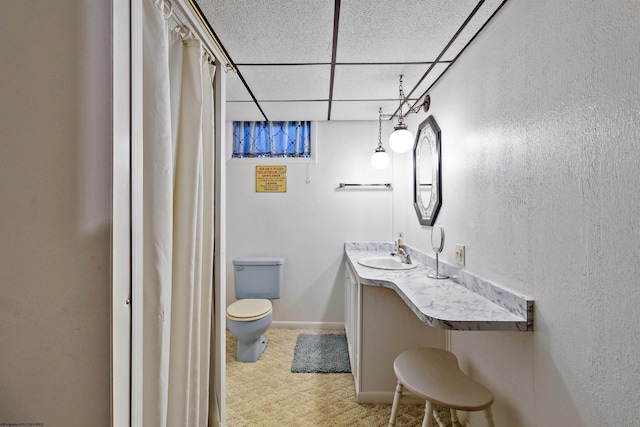 bathroom with toilet, a paneled ceiling, and vanity