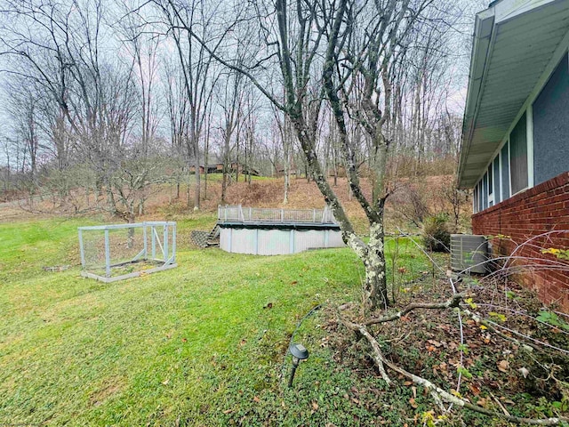 view of yard featuring central air condition unit and a covered pool