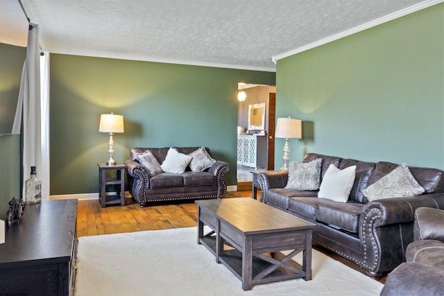 living room featuring wood-type flooring, ornamental molding, and a textured ceiling