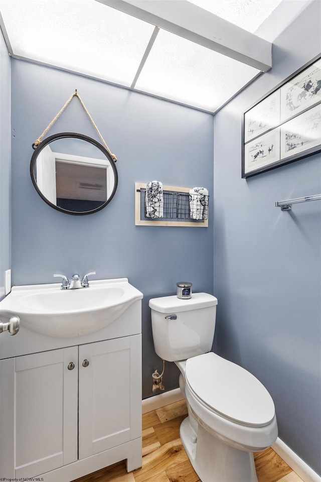 bathroom featuring vanity, toilet, and hardwood / wood-style flooring