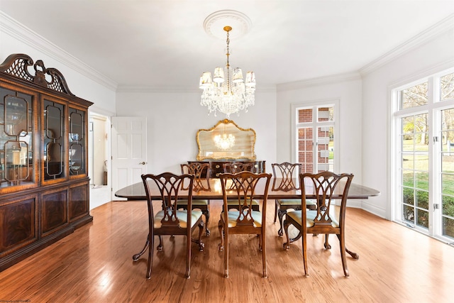 dining area featuring crown molding, light hardwood / wood-style floors, and an inviting chandelier