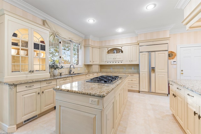 kitchen with paneled fridge, tasteful backsplash, a kitchen island, and stainless steel gas stovetop