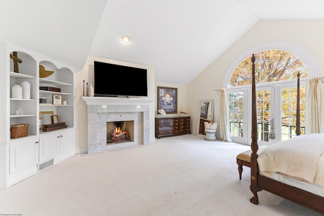 carpeted bedroom with a tiled fireplace, lofted ceiling, and access to exterior