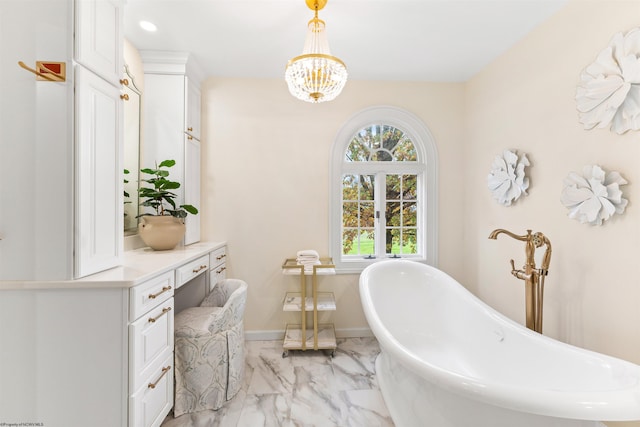 bathroom featuring a tub to relax in, vanity, and a notable chandelier