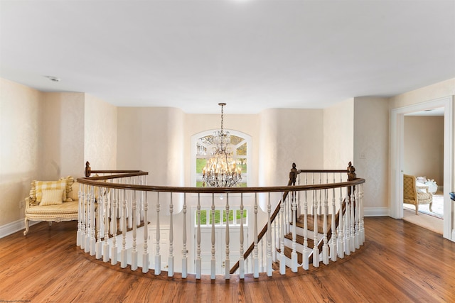 hallway featuring hardwood / wood-style flooring and an inviting chandelier