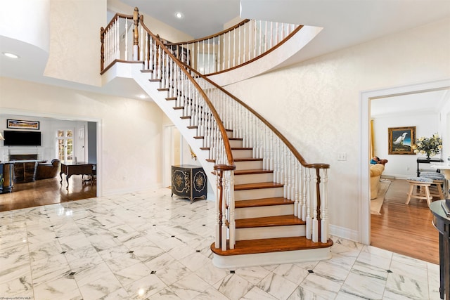 stairway featuring hardwood / wood-style floors and a high ceiling