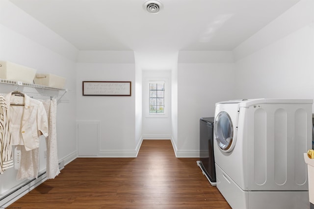 laundry room with washing machine and dryer and dark wood-type flooring