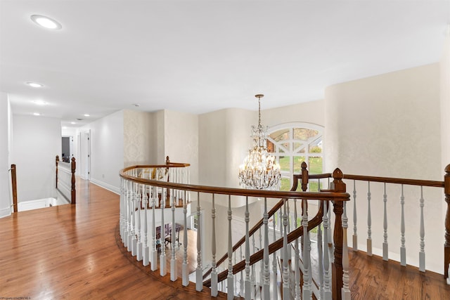 corridor featuring a notable chandelier and wood-type flooring