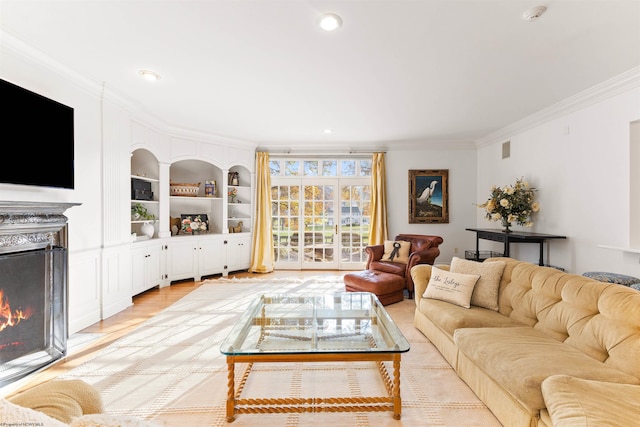 living room with light hardwood / wood-style flooring, ornamental molding, and built in features