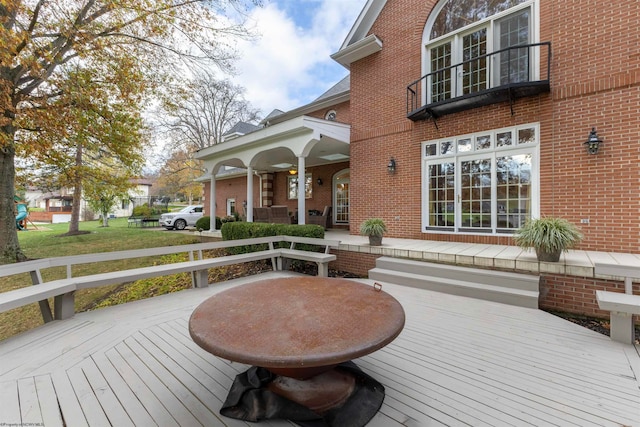 wooden deck featuring a lawn