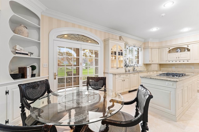 tiled dining area featuring ornamental molding, a healthy amount of sunlight, and sink