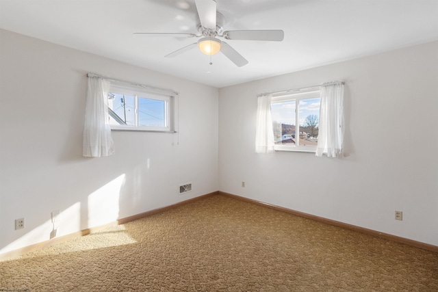 spare room featuring ceiling fan, plenty of natural light, and carpet