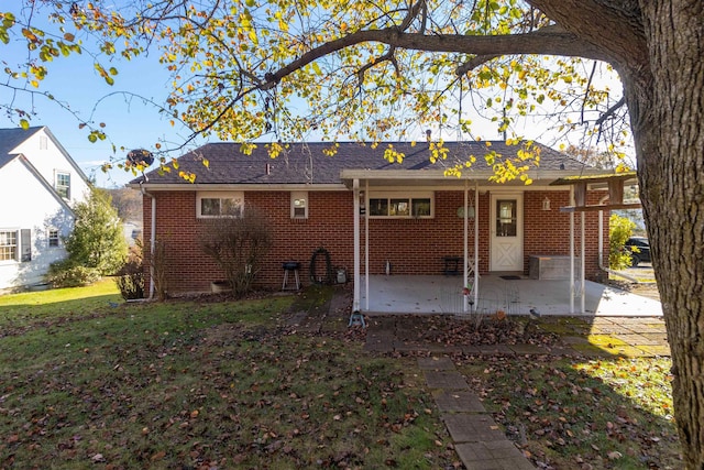 rear view of property with a lawn and a patio area