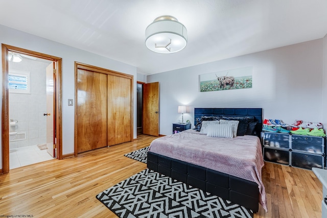 bedroom featuring a closet, hardwood / wood-style floors, and ensuite bathroom