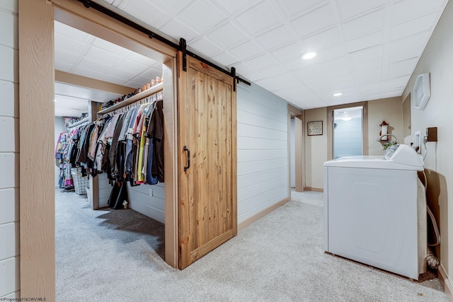 laundry area with washer / clothes dryer and light colored carpet