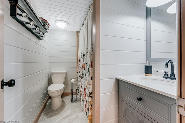 bathroom with wood walls, vanity, and toilet