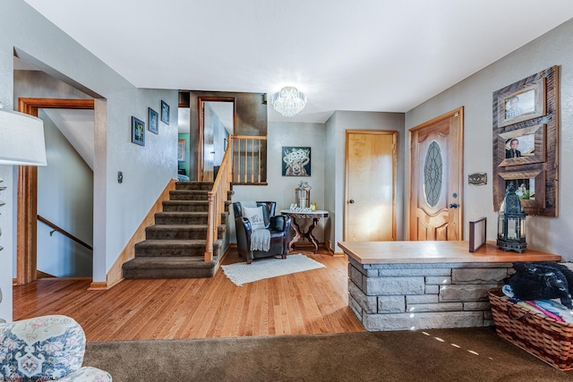 foyer entrance with hardwood / wood-style floors and a chandelier