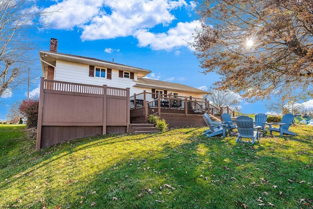 rear view of house with a yard and a wooden deck