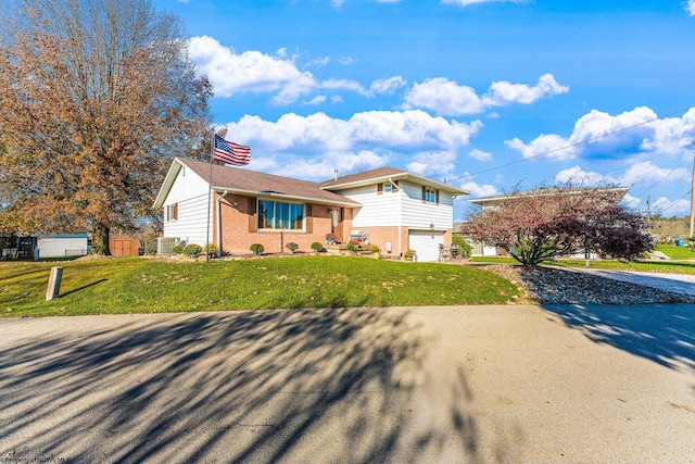 view of front of house featuring a front yard, a garage, and a storage unit