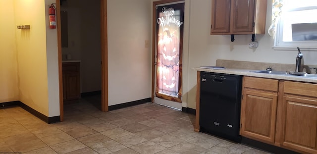 kitchen featuring sink, black dishwasher, and light tile patterned floors