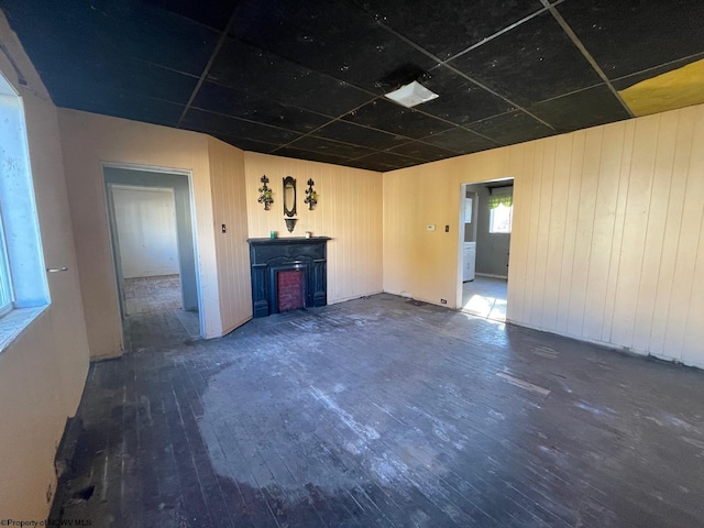 unfurnished living room with wood walls and dark hardwood / wood-style floors