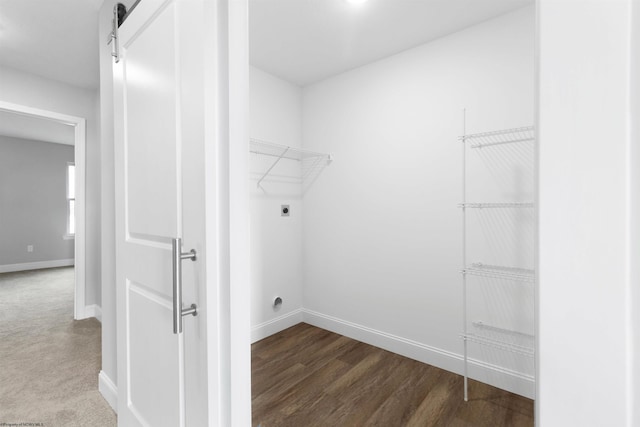 laundry area with a barn door, dark wood-type flooring, and electric dryer hookup