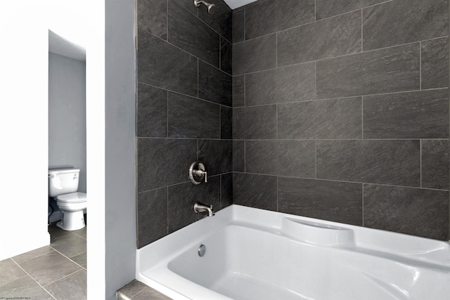 bathroom with tile patterned flooring, tiled shower / bath combo, and toilet