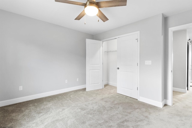 unfurnished bedroom featuring ceiling fan, a closet, and light colored carpet