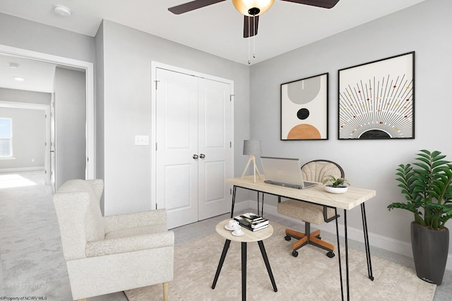 home office featuring ceiling fan and light carpet