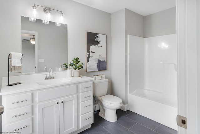 full bathroom featuring tile patterned floors, vanity, ceiling fan, washtub / shower combination, and toilet