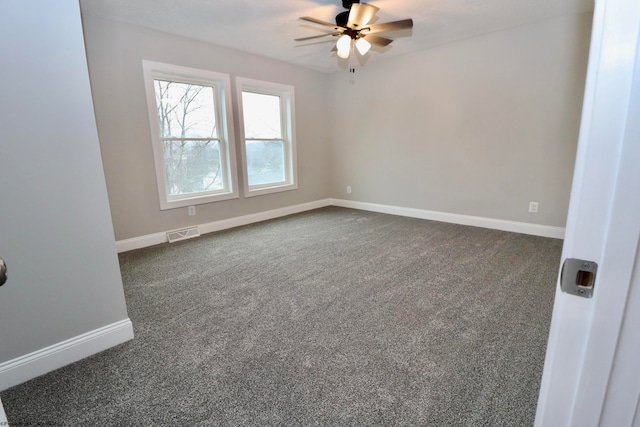 spare room featuring ceiling fan and dark carpet