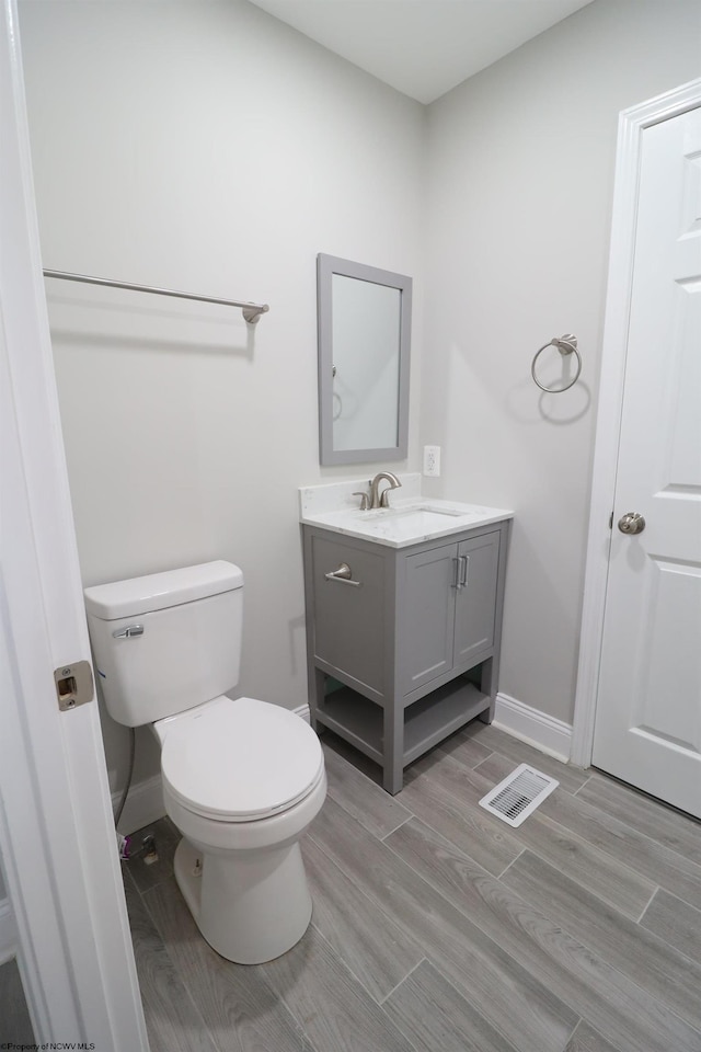 bathroom featuring hardwood / wood-style floors, vanity, and toilet