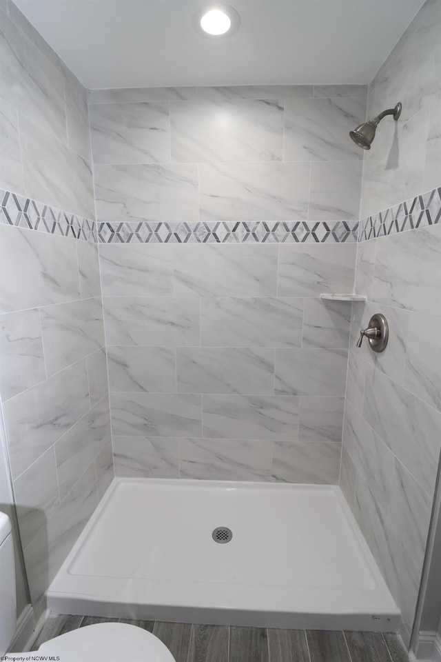 bathroom with toilet and tiled shower