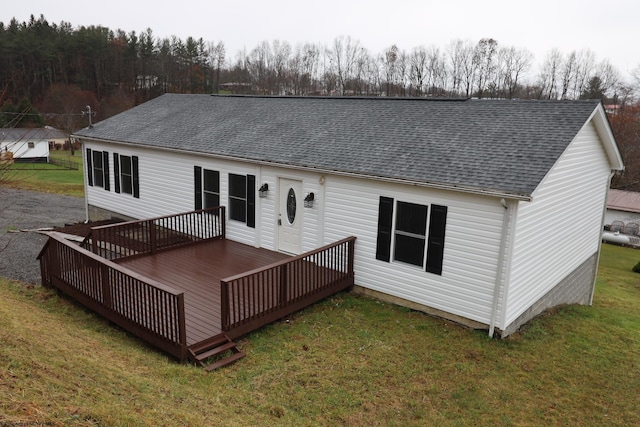 rear view of property with a yard and a deck