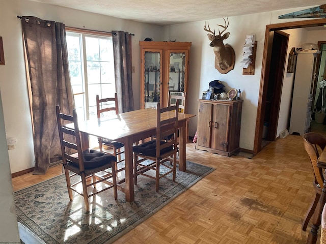 dining room featuring a textured ceiling and light parquet flooring