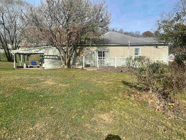 rear view of house with a deck and a yard