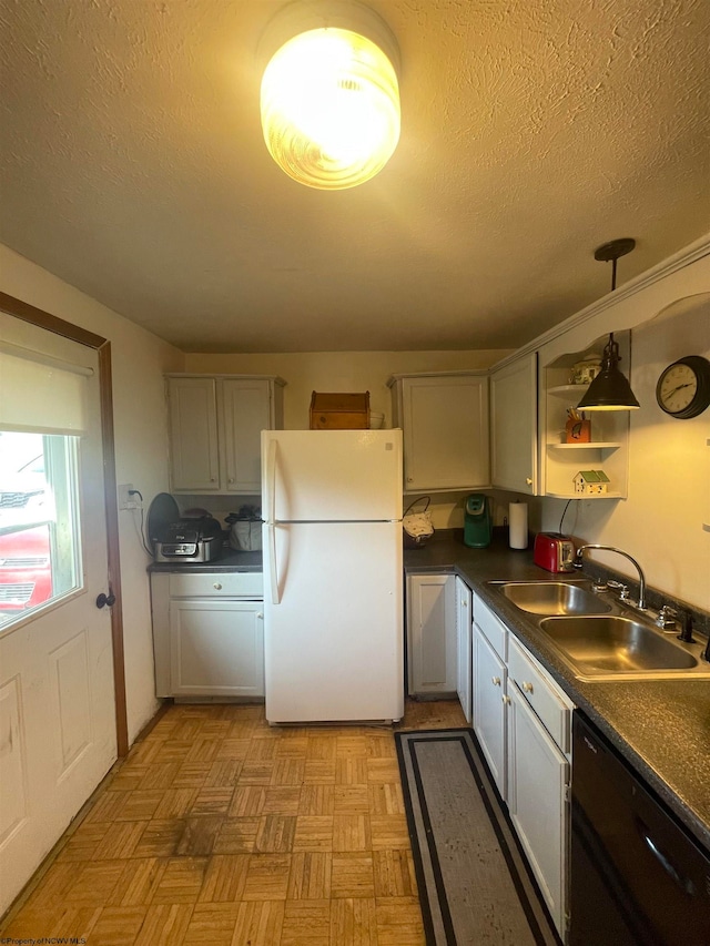 kitchen with light parquet floors, sink, black dishwasher, decorative light fixtures, and white fridge