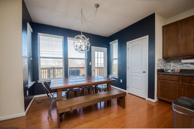 dining room with hardwood / wood-style floors and an inviting chandelier