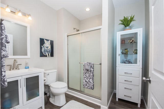 bathroom with wood-type flooring, vanity, toilet, and an enclosed shower