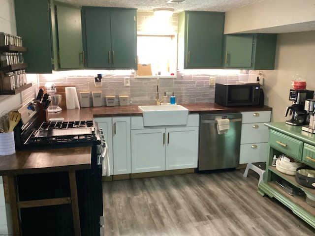 kitchen featuring wooden counters, appliances with stainless steel finishes, a textured ceiling, and green cabinetry