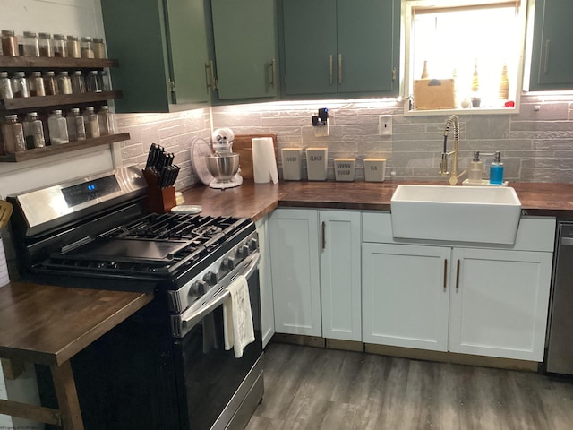 kitchen featuring stainless steel appliances, butcher block countertops, dark wood-type flooring, and sink